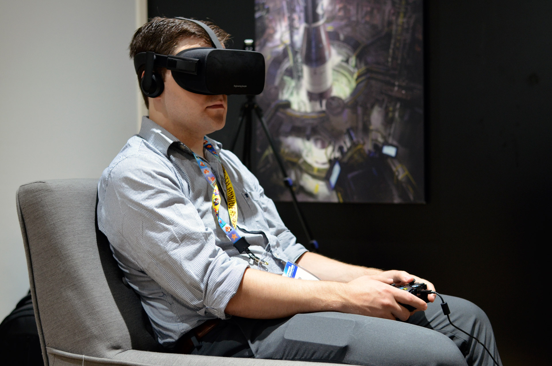 A man on his couch with a VR headset turning his head while holding a controller